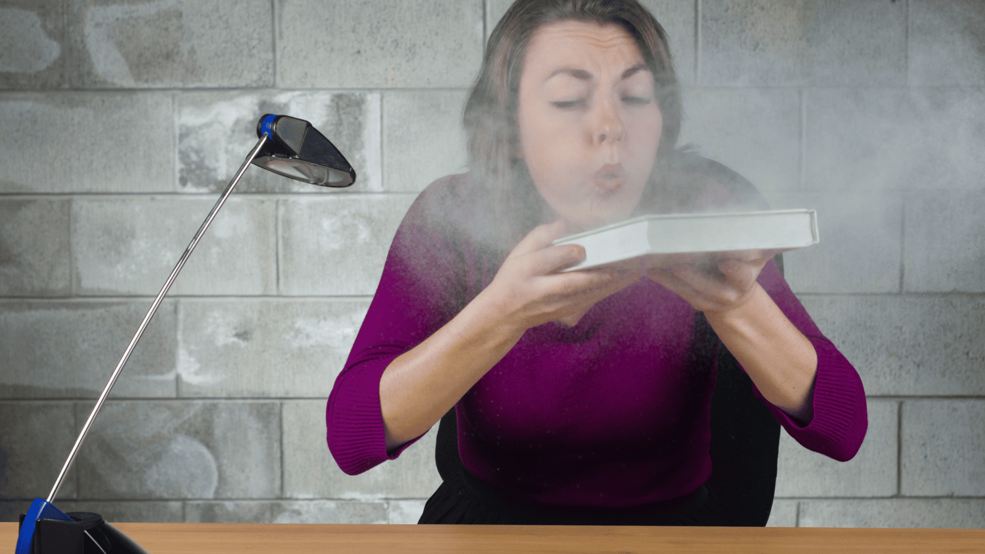 woman blowing dusty book
